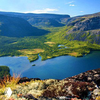 Горное северное озеро с чистой тёмно-голубой водой и окружающими скалами и тайгой — типичный вид для Сейдозера и Кольского региона.