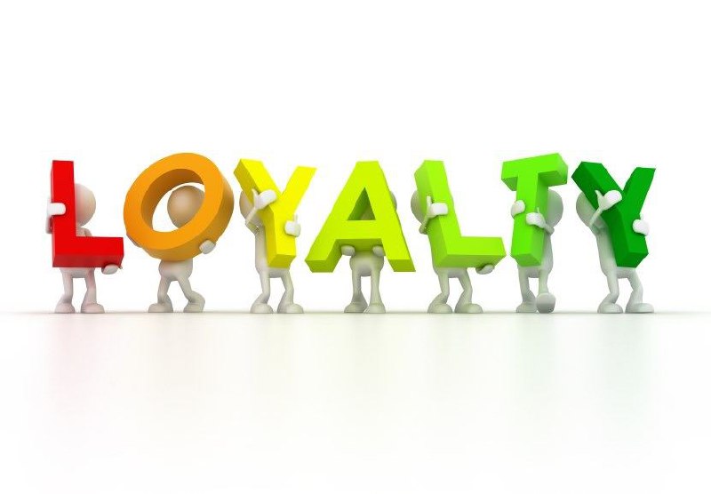 Фигурки держат цветные буквы, складывающие слово LOYALTY на белом фоне; иллюстрация концепта лояльности сотрудников.