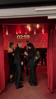 Группа людей у красной занавески и большого таймера на экране — подготовка к выходу на сцену и начало следующего блока программы.