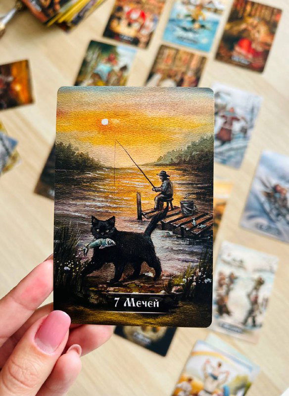 Крупный план карты «7 Мечей» в руке: рыболов на причале и собака на переднем плане, хорошо видна текстура и детализация иллюстрации.