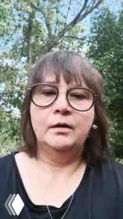 Фрагмент вертикального ролика: женщина в очках на фоне деревьев рассказывает о результатах после участия в курсе, виден портретный кадр.