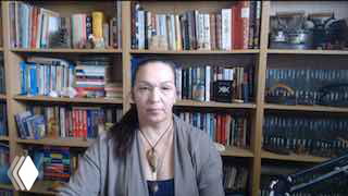 Горизонтальный кадр: женщина на фоне полки с книгами в кабинете, говорит в камеру — профессиональный отзыв участницы потока «Блудный Контент».