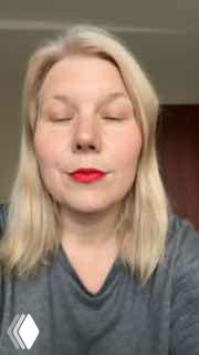 Кадр вертикального видео: светловолосая женщина с красной помадой обращается к камере — фрагмент отзывов о навыках письма после курса.