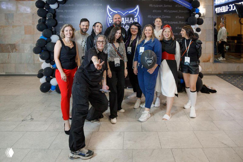 Групповое фото участников мероприятия у входа: организаторы и подписчики стоят вместе, атмосфера знакомства и нетворкинга после конференции.