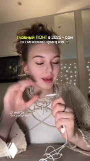 Кадр видео: девушка с наушниками говорит о сне как новом статусном символе 2025, на экране заголовок про зумеров.