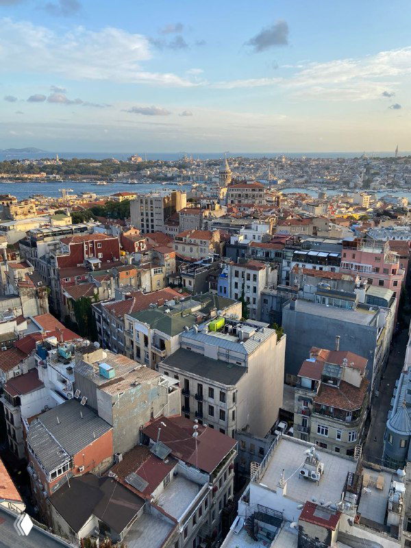 Дневной вид с высоты на плотную застройку Стамбула у побережья, крыши зданий и пролив, снято с высоты 18 этажа.