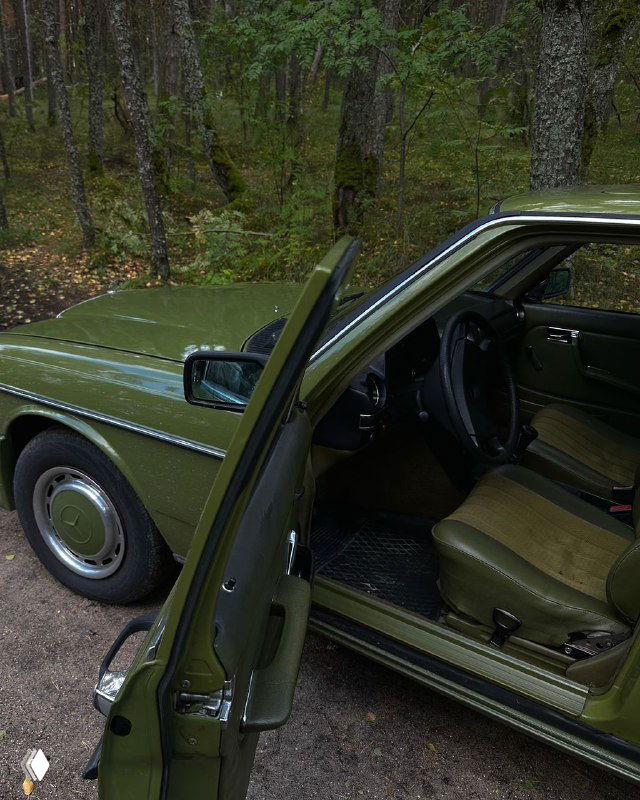 Ретро‑мерседес цвета хакки в лесной или пригородной обстановке: открытая дверь, вид на внутренний салон и детали интерьера автомобиля тура.