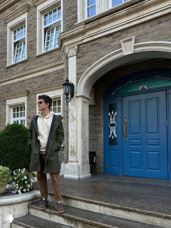 Городская сцена в районе немецких вилл Амалиенау: старинный фасад с голубой дверью и прохожий в стиле casual, показывающая атмосферу прогулок по району.