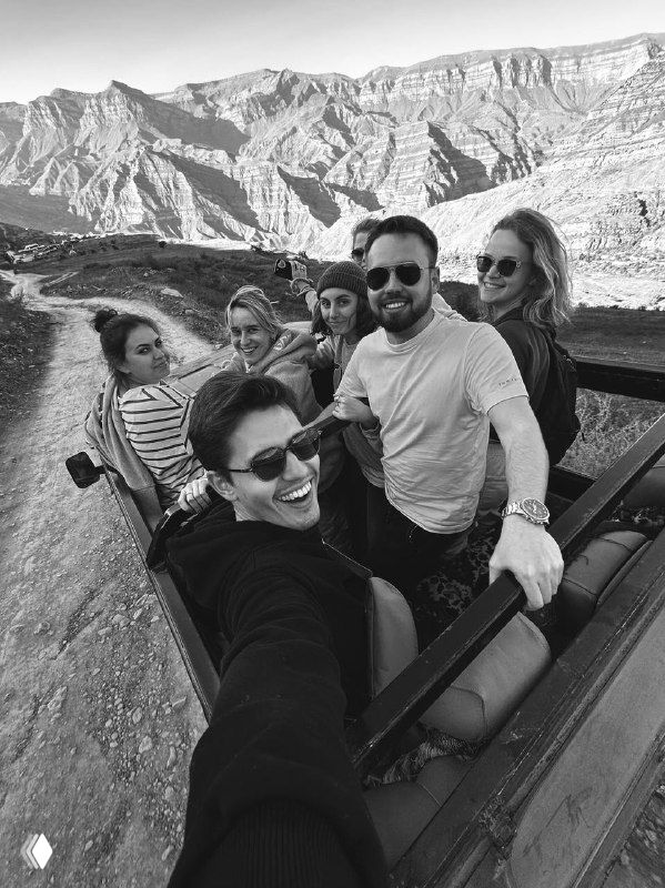 Группа путешественников делает селфи на смотровой платформе в горах Дагестана: улыбающиеся лица на фоне широких горных пейзажей.