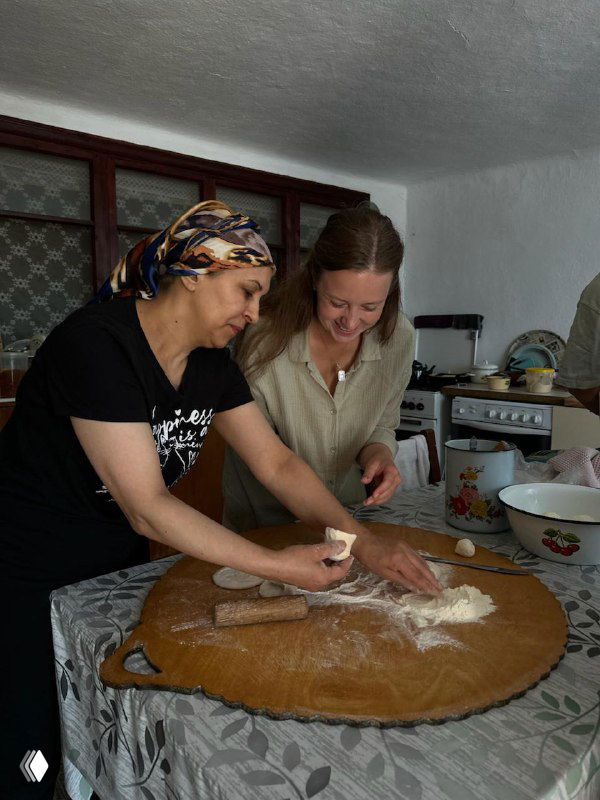 Готовка в домашней кухне: женщины вместе раскатывают тесто и делятся рецептами — часть аутентичного гастрономического опыта.