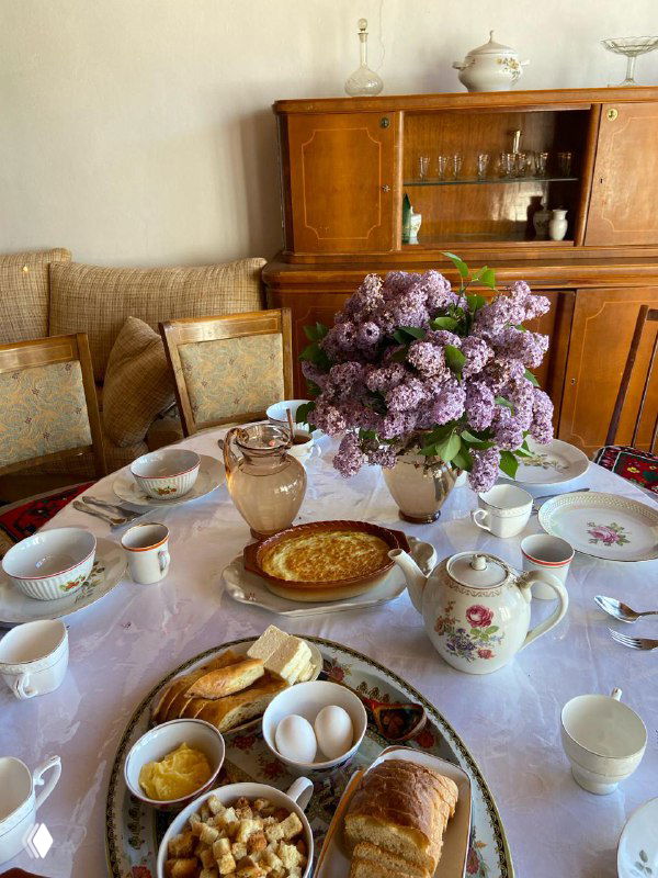 Завтрак на столе дома в ауле: домашние яйца, хлеб, варенья и чай — свежие продукты и уютный размеренный утренний ритуал.