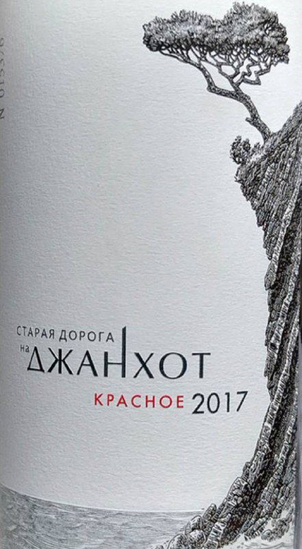 Крупный план этикетки вина «Старая дорога на Джанхот» красное 2017: текст и графическая гравюра на бумажной этикетке бутылки.