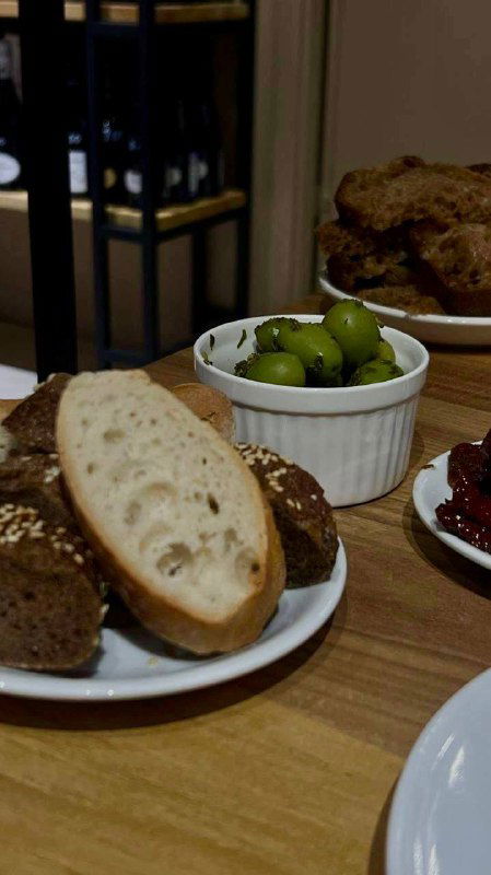 Хлеб, оливки и закуски на деревянном столе — детали сервировки и аперитивы к дегустации вулканических вин.