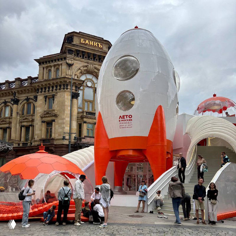 Детская игровая композиция в виде ракеты и надувных куполов, вокруг люди и дети — интерактивные арт-объекты проекта для семейного отдыха.
