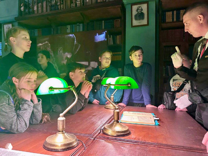 Дети на экскурсии внутри музея: группа подростков слушает рассказ, атмосфера образовательной активности и музейной программы в рамках лагеря.