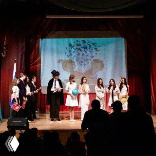 Сцена в школьном театре с выступающими учениками — школьный спектакль, костюмы и реквизит, коллективные творческие активности учащихся.