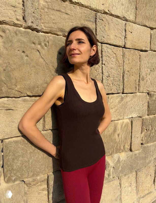 Портрет Виктории на фоне массивной каменной стены в старой части Баку, солнце освещает лицо, тёплая городская атмосфера и летняя одежда