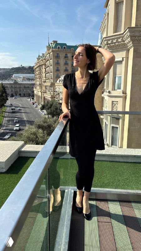 Женский портрет на фоне городской набережной Баку, балкон отеля и вид на городские улицы в солнечном свете, стильная прогулка