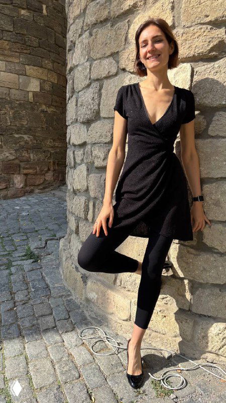 Виктория в платье на фоне каменной архитектуры Старого города, солнечный день, прогулочный образ и историческая атмосфера вокруг