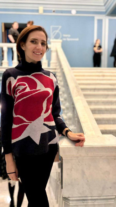 Автор канала в фойе Театра на Бронной у мраморной лестницы, улыбается в вечерней одежде перед походом на спектакль