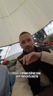 Мужчина в куртке сидит под зонтом в кафe на фоне цветов; кадр используется как промо-изображение для сервиса автоматизации страницы.