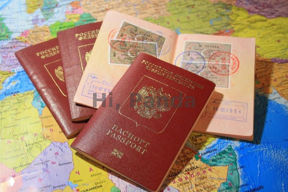 Несколько российских заграничных паспортов с печатями и штампами, разложенных на карте мира — иллюстрация виз и транзита.