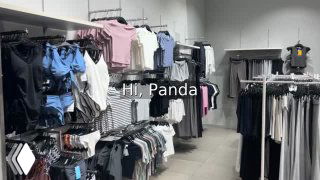 Интерьер магазина одежды: вешалки с футболками, спортивная экипировка и стеллажи в торговой зоне ТЦ Mangrove Tree Sanya.