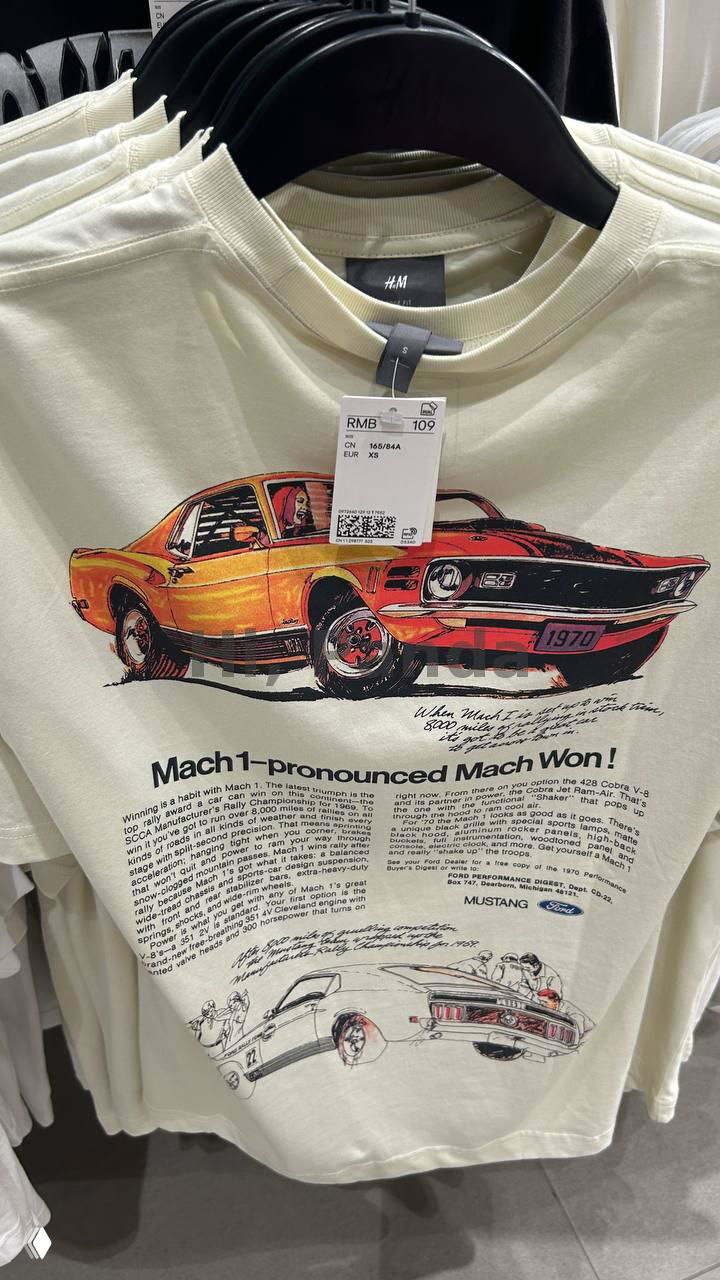 Фотография светлой футболки H&M с крупным принтом ретро-автомобиля и видимой биркой RMB 109, вешалка и интерьер магазина в ТЦ Mangrove Tree Sanya.