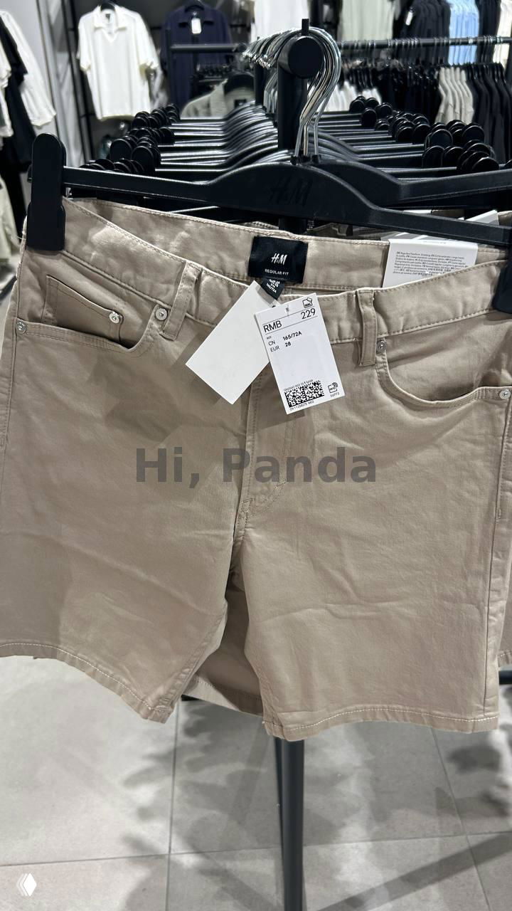 Бежевые шорты H&M на вешалке с биркой и ценником RMB 229, рядом другие вещи на стойке в магазине Mangrove Tree Sanya.