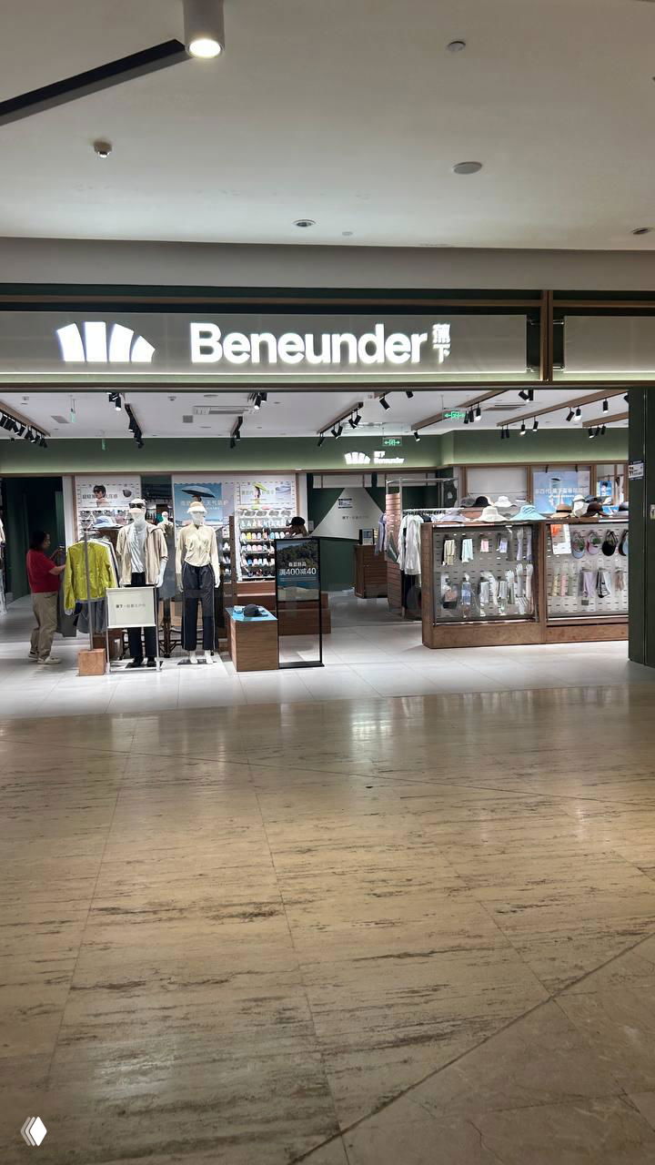 Внутренний вид торгового центра Mangrove Tree Sanya: вход в магазин Beneunder, витрина с одеждой и спокойный коридор торгового зала.