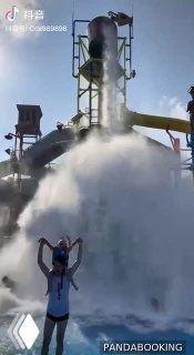 Большая падающая чаша и сильный водяной поток на фоне горок: эффектный момент спуска с большой чаши с брызгами и радующимися посетителями.