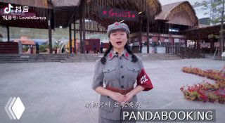 Артист в революционной военной форме на открытой сцене шоу «Красный женский отряд» в Санье; видны декорации и логотип Pandabooking.