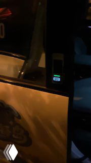 Кадр ночной улицы и открытой двери беспилотного такси с заметной графикой на боковой поверхности автомобиля, съёмка подчёркивает внешний вид и брендинг машины.