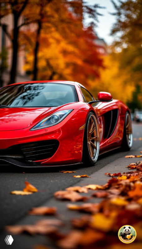 Вертикальные обои: красный спортивный автомобиль на дороге среди опавших листьев, динамичная сцена с ярким контрастом машины и тёплой осенней обстановки для телефона.