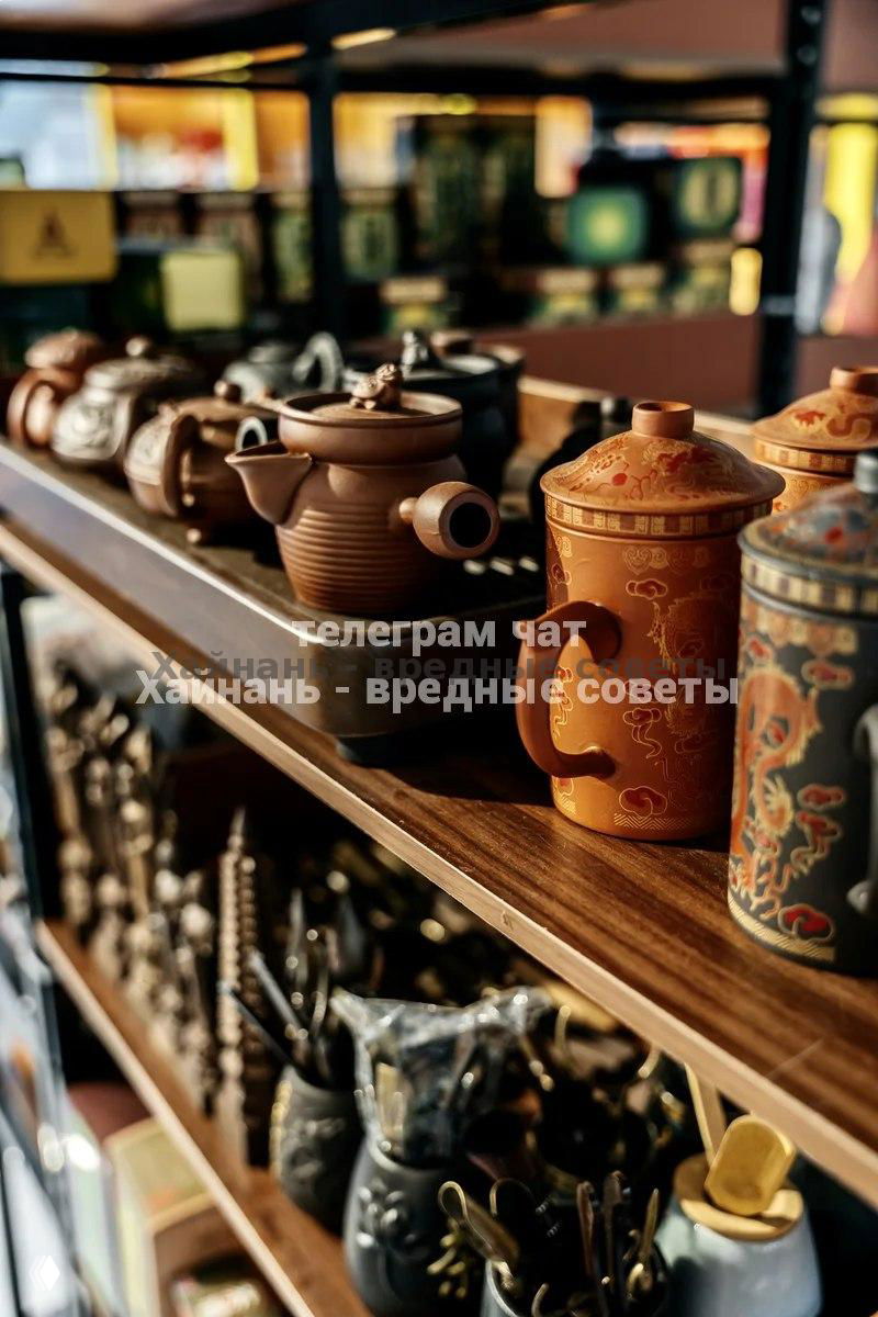 Полка с традиционными чайниками и чайными аксессуарами: глиняные и керамические емкости разных форм и оттенков.