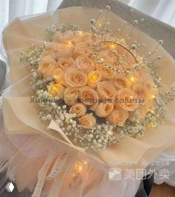 Нежный букет бежево-персиковых роз с гипсофилой и декоративной короной, оформленный в мягкую бумагу с подсветкой — стильная композиция для подарка в отель.