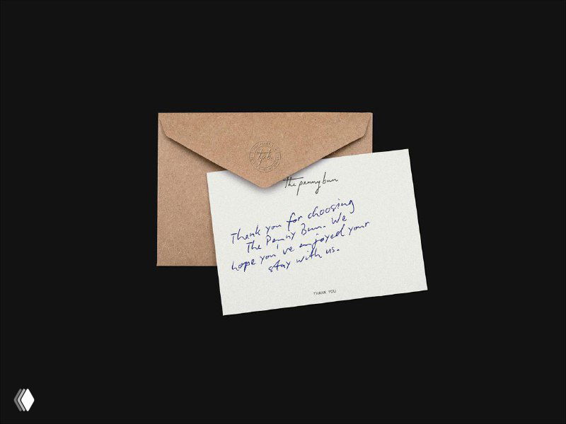 Светло-коричневый конверт и открытка с рукописным текстом на тёмном фоне, пример фирменной полиграфии для паба The Penny Bun.