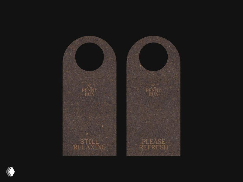 Дверные вешалки из фактурного тёмного картона с золотым тиснением логотипа и надписями, монохромная айдентика паб-бренда.