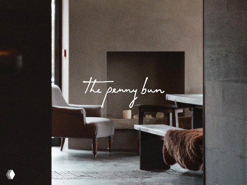 Интерьер паба с мягкими креслами и рукописным логотипом на фоне, подчёркнута уютная атмосфера заведения.