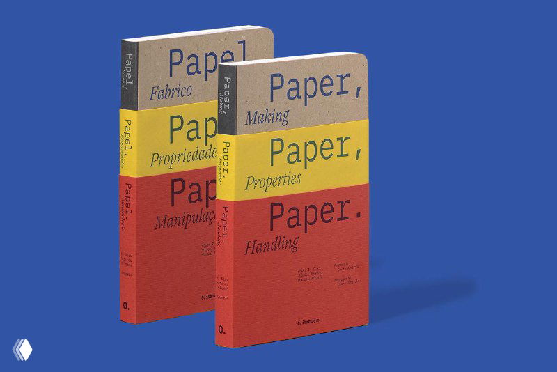 Две копии книги «Paper, Paper, Paper» на синем фоне; видны красные и жёлтые обложки, типографика и аккуратная верстка, подчёркивающие дизайн