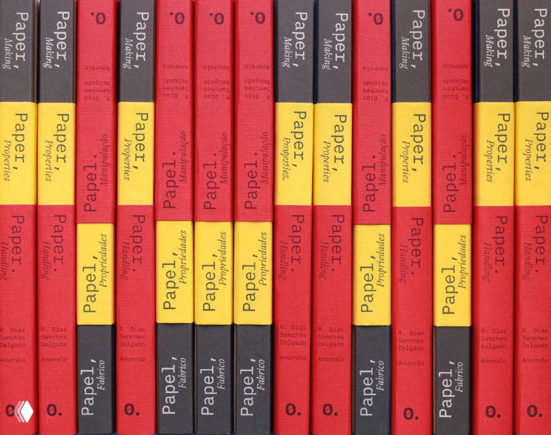 Ряд переплетов книги «Paper, Paper, Paper» с повторяющимися корешками в красно‑жёлтой палитре; виден единый стиль дизайна и маркировка томов