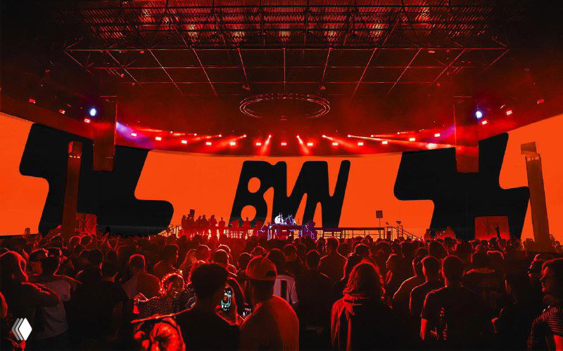 Концертная сцена с оранжевыми визуалами и крупным логотипом BVN на экране — применение айдентики в лайв‑шоу, световых и сценических решениях.