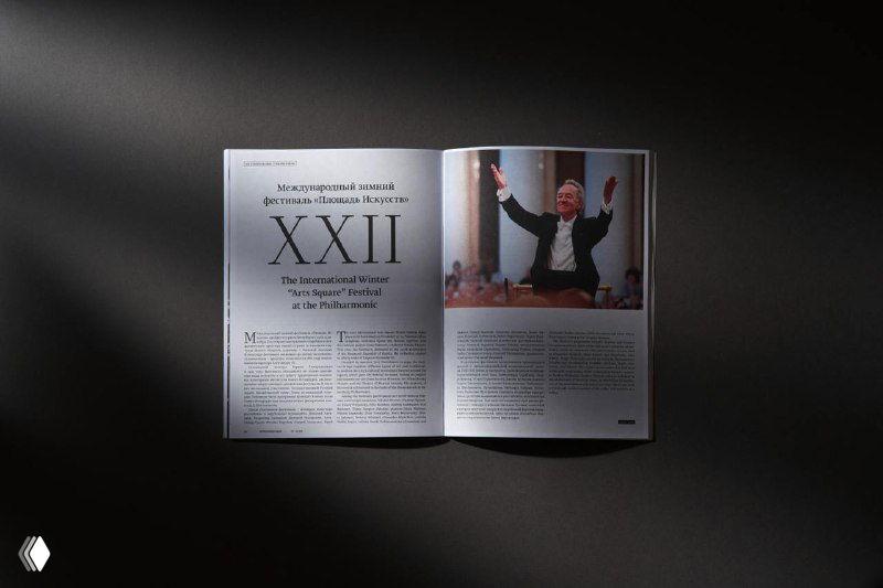Разворот журнала со статьёй и крупным фото выступления: текстовые колонки, фотография в зале и выразительная типографика в световом пятне.
