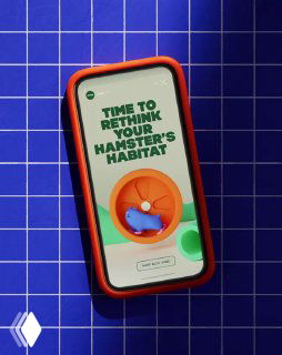 Мокап мобильного интерфейса с надписью «TIME TO RETHINK YOUR HAMSTER'S HABITAT» на синей решётчатой подложке, игривый дизайн для товаров мелких животных