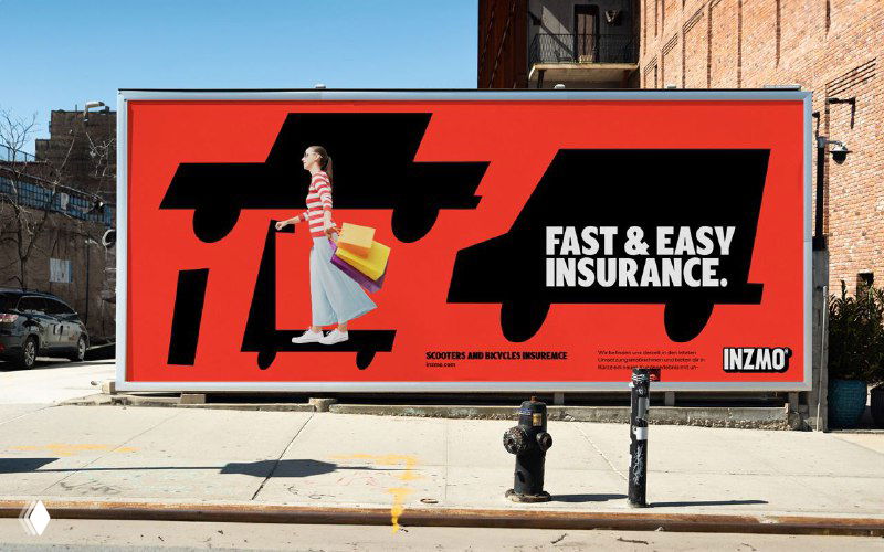 Уличный билборд с ярко-красным фоном и крупным слоганом Fast & Easy Insurance; рекламная визуализация бренда Inzmo в городской среде.
