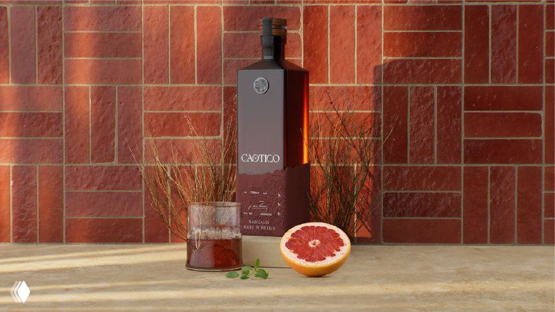 Бордовая концепт‑бутылка Caotico на фоне кирпичной плитки, рядом грейпфрут и стакан коктейля, студийная фотография с тёплыми тонами.