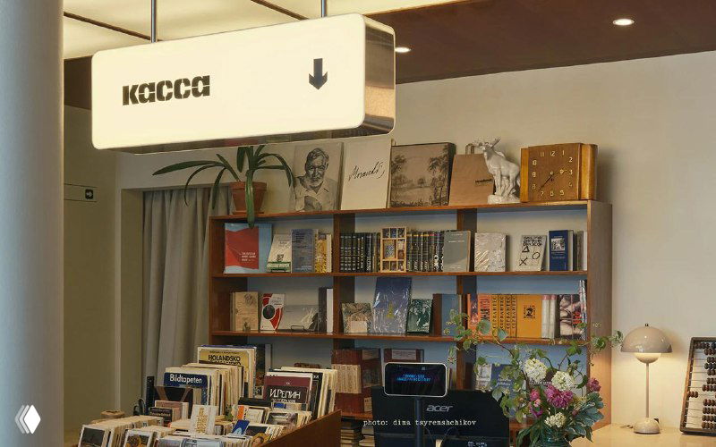 Кассовая зона и книжные полки: внутреннее пространство букинистического магазина с вывеской «касса», книгами на полках и уютным оформлением.