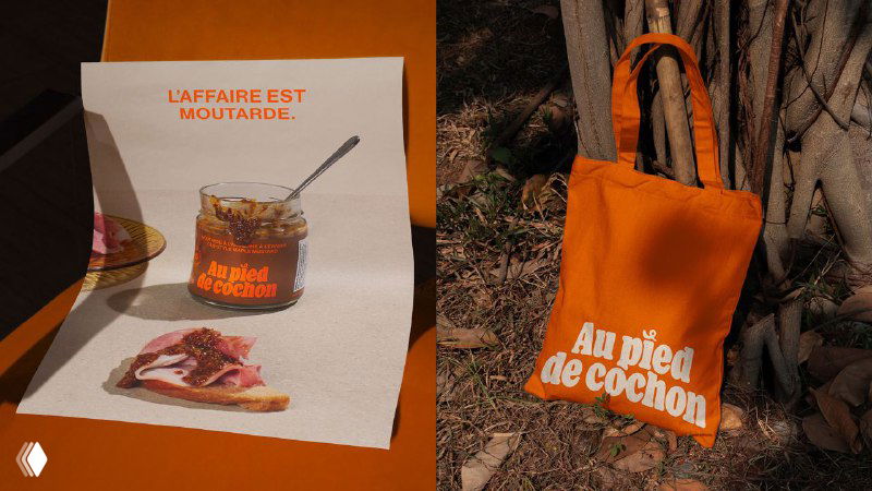 Постер и оранжевая сумка с логотипом Au Pied de Cochon на уличной сцене; визуализация применения фирменного стиля на мерче и печатной продукции.