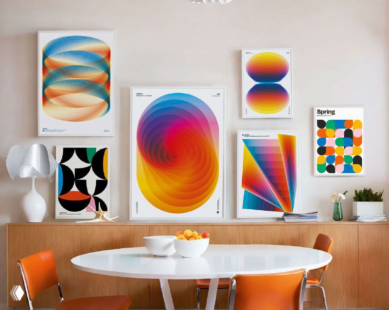 Интерьер с несколькими рамочными плакатами Вратислава Пецки: яркие спиральные и геометрические абстракции, размещённые над столом.