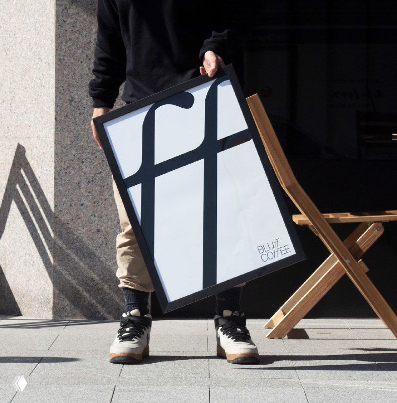 Плакат с крупной лигатурой «ff» в рамках, снятый под углом на ступенях — визуальный акцент на графическом элементе фирменного стиля.